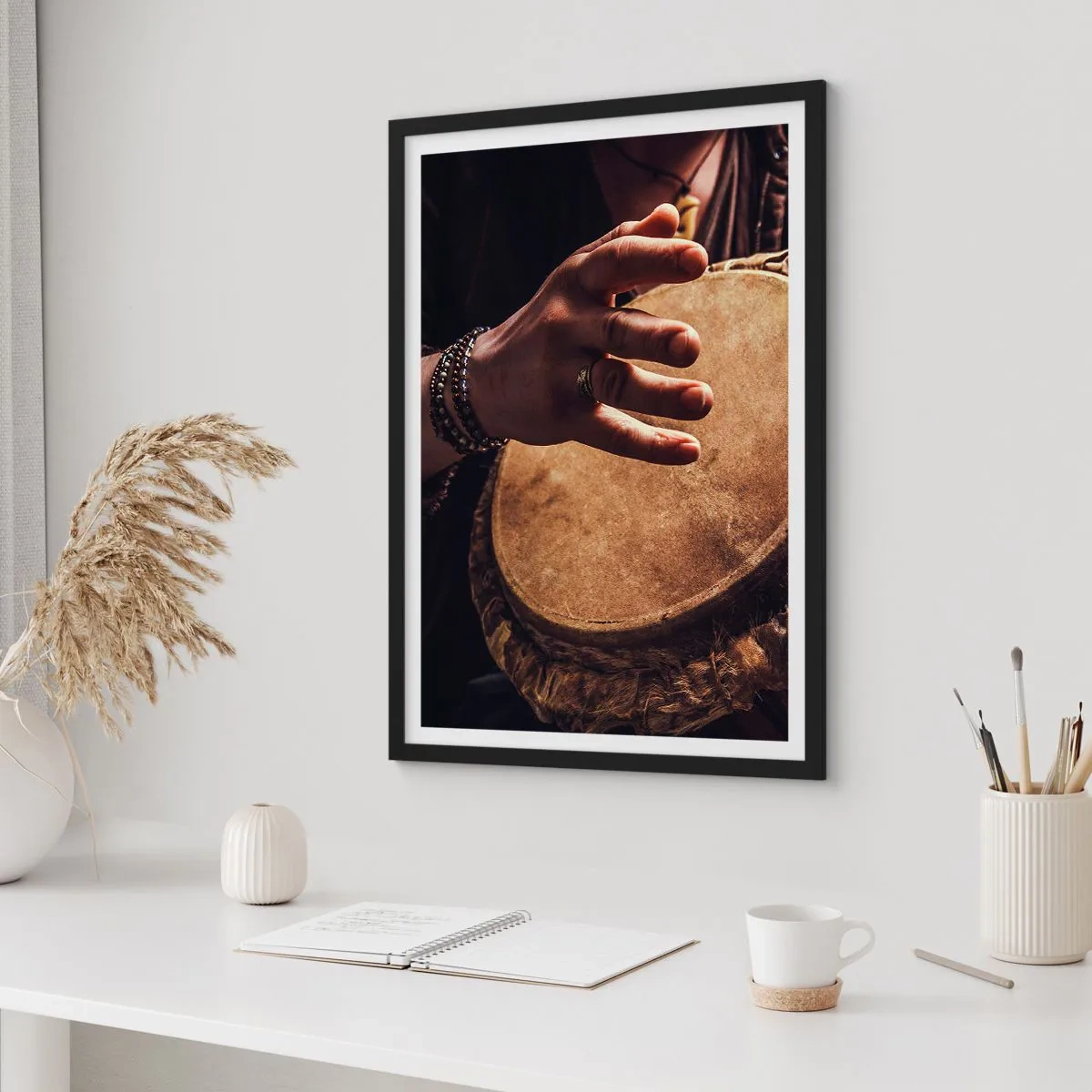 Póster en marco negro - Una mano tocando un tambor bajo una luz cálida. - 50x70cm - En el ritmo del corazón - Decoración de pared moderna para salón y dormitorio ARTTOR