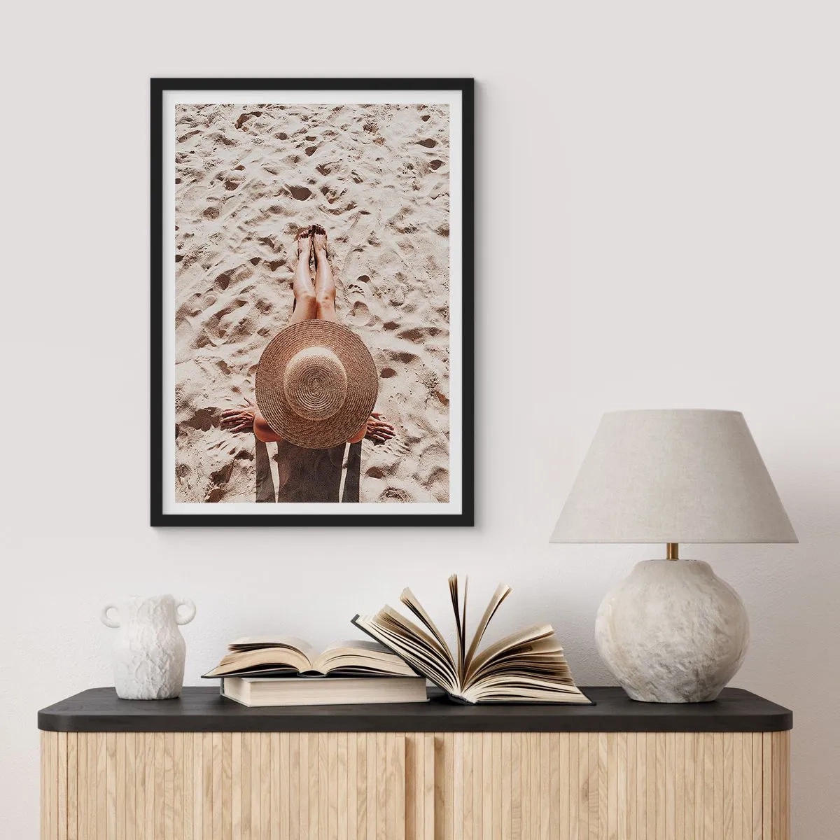 Póster en marco negro - Persona tomando el sol en la playa, vista superior con un sombrero grande contra la arena. - 50x70cm - Un tiempo de ensueño - Decoración de pared moderna para salón y dormitorio ARTTOR