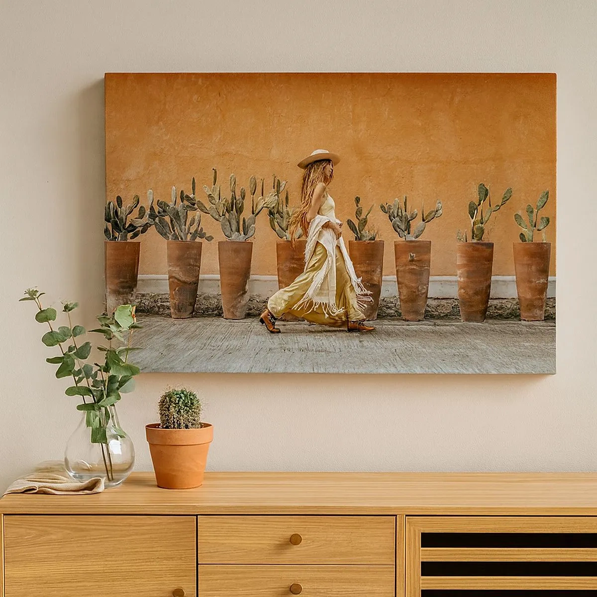 Cuadro sobre lienzo - Impresión de Imagen - Una mujer en estilo boho con macetas de cactus al fondo. - 70x50cm - Estilo hippie - Decoración de pared moderna para salón y dormitorio ARTTOR